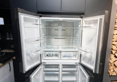 Geöffneter Bosch French-Door-Kühlschrank mit breitem Kühlraum, Glasablagen, Türfächern, Frischeschubladen und separaten Gefrierschubladen in der Ausstellungsküche.